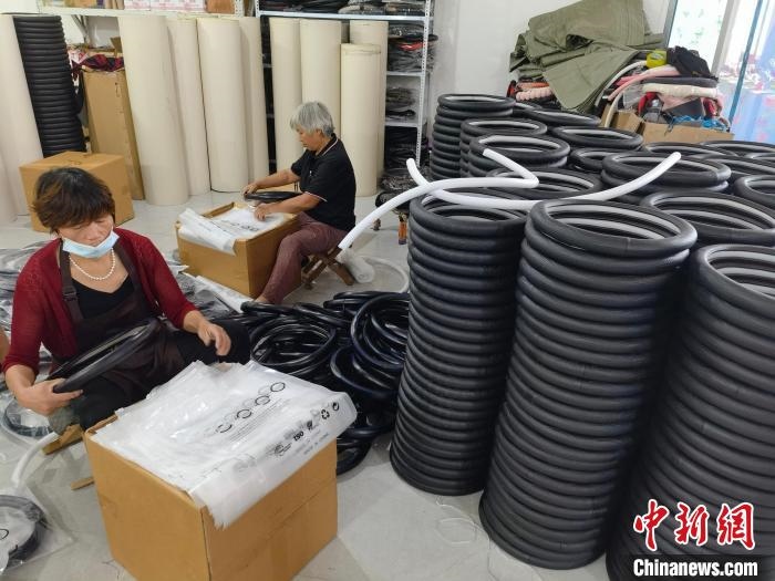 圖為村民在汽車飾品企業(yè)生產(chǎn)車間中工作?！巫雍?攝