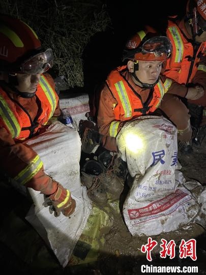 短暫修整期間，消防員脫掉鞋襪，用編織袋套住腿腳保暖。　閆旭輝 攝