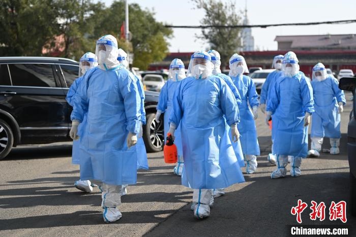 圖為醫(yī)務(wù)人員在封閉小區(qū)做防控工作?！⑽娜A 攝