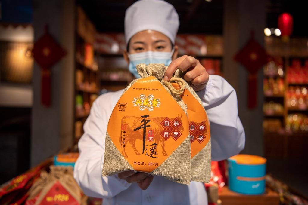 1月27日，在平遙古城南大街的一家平遙牛肉店內(nèi)，工作人員展示一款牛肉產(chǎn)品。新華社記者 楊晨光 攝