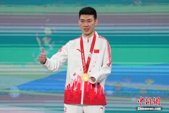 3月6日，梁景怡在延慶頒獎(jiǎng)廣場領(lǐng)獎(jiǎng)臺(tái)上豎起大拇指。當(dāng)日，在國家高山滑雪中心舉行的北京2022年冬殘奧會(huì)殘奧高山滑雪男子超級(jí)大回轉(zhuǎn)—站姿決賽中，中國選手梁景怡奪得冠軍。 <a target='_blank' href='/'>中新社</a>記者 楊華峰 攝