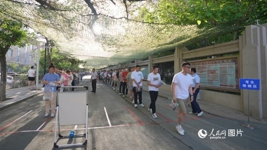 6月7日，烏魯木齊市第七十中學(xué)門口，考生們有序進入考場。人民網(wǎng) 李欣洋攝