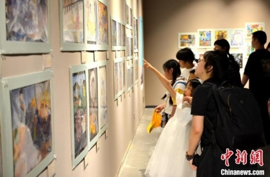 圖為家長帶著孩子參觀展覽。呂明 攝