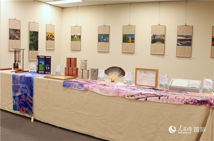 現(xiàn)場(chǎng)展出的馮學(xué)敏攝影作品與湖州市特色工藝品。（人民網(wǎng) 許可攝）