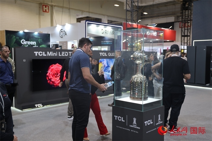 參觀者在TCL展臺(tái)前觀看南美解放者杯獎(jiǎng)杯，據(jù)介紹，TCL是南美解放者杯（2023—2026賽季）全球官方合作伙伴。（人民網(wǎng)記者 時(shí)元皓攝）
