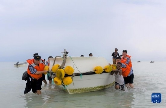 7月21日，中國海軍“和平方舟”號醫(yī)院船醫(yī)護人員涉水登島，前往基里巴斯一診療點。新華社記者 黎云 攝