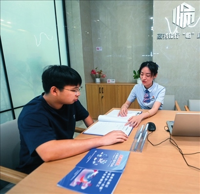 在杭州市臨安區(qū)政務(wù)服務(wù)中心的“為企服務(wù)中心”，黨員志愿者（右）解答企業(yè)主的疑問（2023年7月7日攝）。徐昱攝/本刊