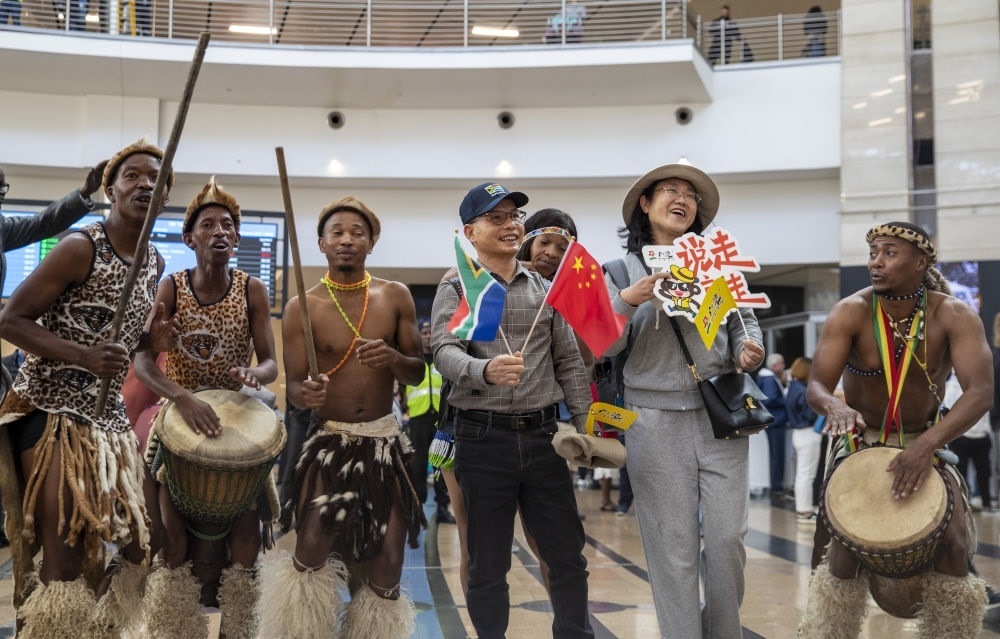 在南非約翰內(nèi)斯堡坦博國際機(jī)場，南非舞蹈演員歡迎中國試點(diǎn)恢復(fù)出境團(tuán)隊(duì)旅游后首批抵達(dá)南非的中國游客（2023年3月29日攝）。
