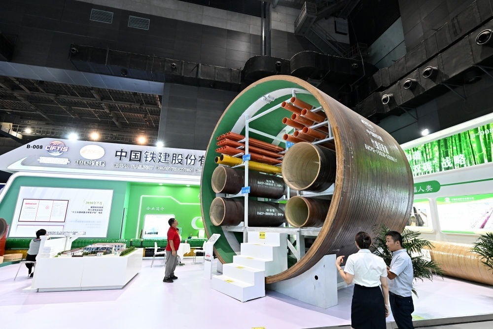 9月2日，在國家體育館舉行的服貿(mào)會(huì)環(huán)境服務(wù)專題展上，客商在中國鐵建展位竹纏繞管廊旁了解信息。新華社記者 李鑫 攝