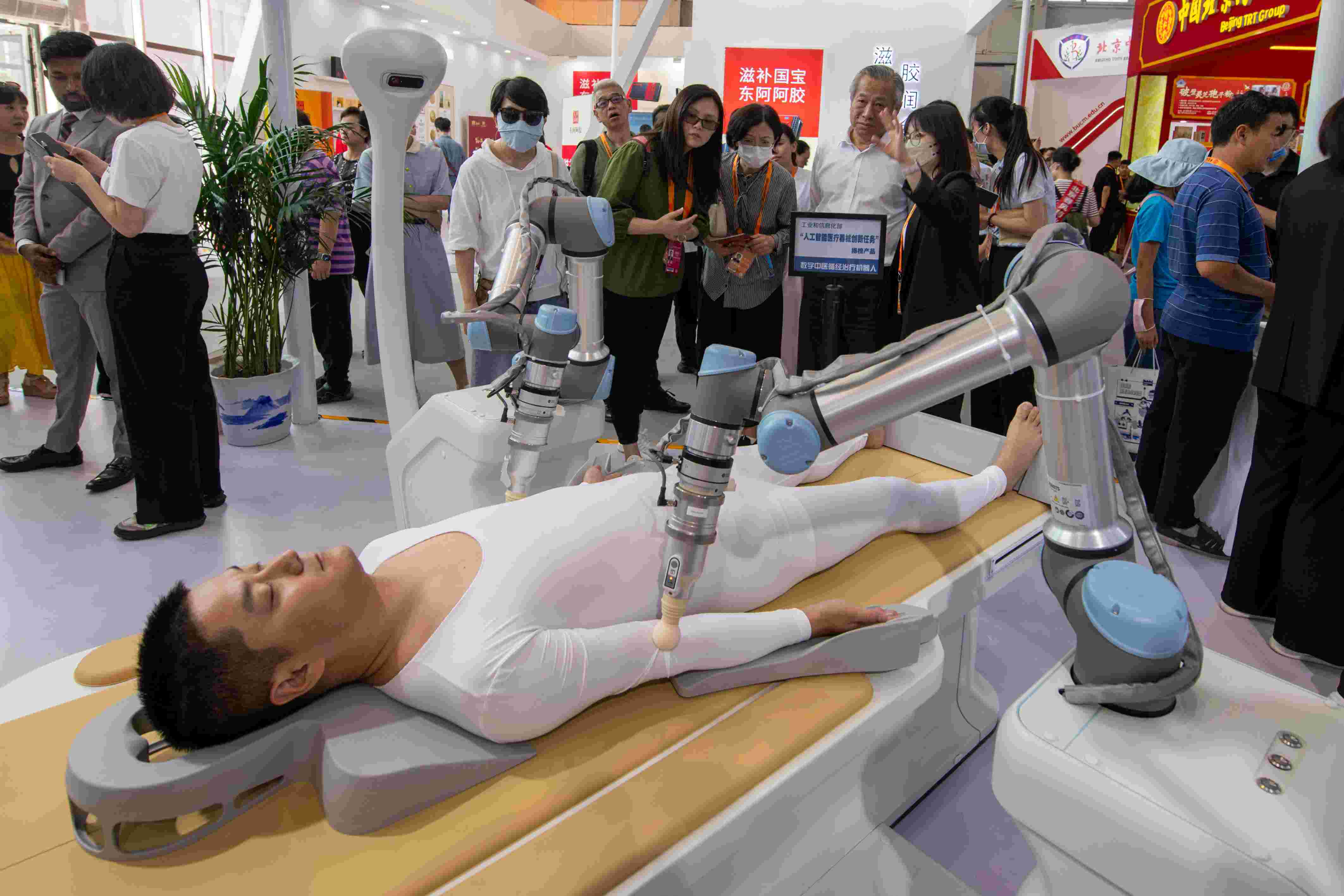 在位于首鋼園的健康衛(wèi)生服務(wù)展區(qū)，觀眾正在參觀數(shù)字中醫(yī)循經(jīng)治療機(jī)器人。人民網(wǎng)記者 翁奇羽攝
