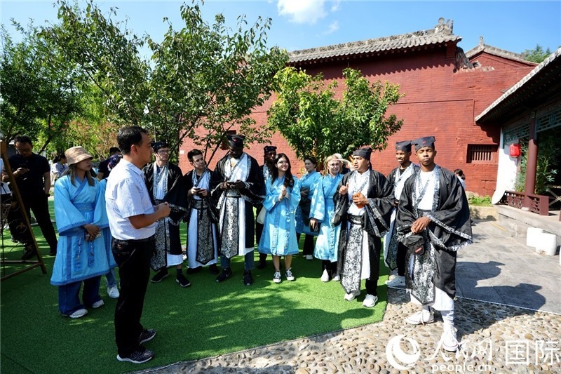 圖為選手們聽導(dǎo)游講解。人民網(wǎng) 盧鵬宇攝