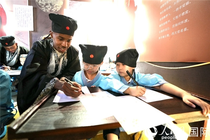 圖為選手與同學(xué)們一起寫書法。人民網(wǎng) 盧鵬宇攝