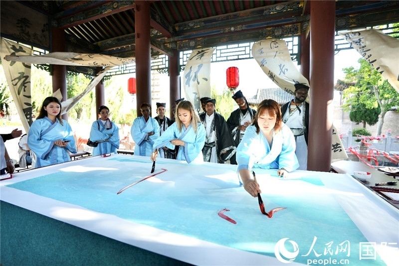 選手們提筆書寫“家園”二字。人民網(wǎng) 盧鵬宇攝