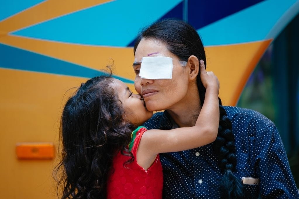 2019年3月15日，在柬埔寨磅湛省醫(yī)院，即將接受白內(nèi)障手術(shù)的患者孫美樂接受女兒的親吻祝福。在接受了中國醫(yī)療隊的白內(nèi)障義診手術(shù)后，她的視力逐步恢復(fù)，生活有了新的光明和希望。