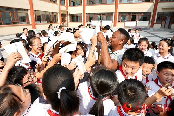 孩子們和選手互動(dòng)簽名。人民網(wǎng) 盧鵬宇攝