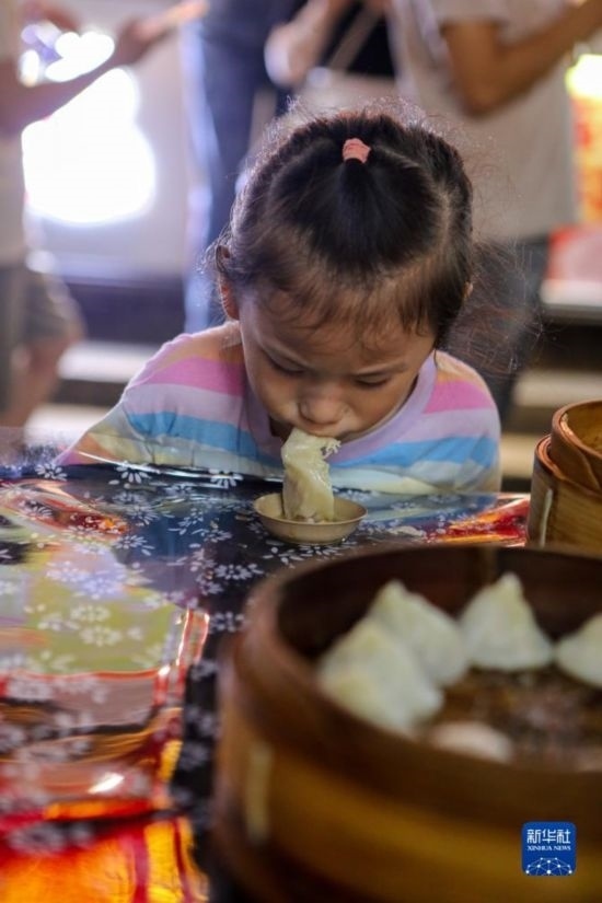 9月27日，小朋友在南翔小籠長(zhǎng)街宴上品嘗南翔小籠。