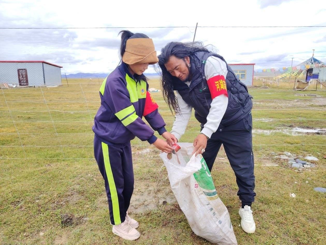 玉樹州稱多縣珍秦鎮(zhèn)河湖志愿者才培和他女兒更求拉毛在清掃垃圾。受訪者供圖