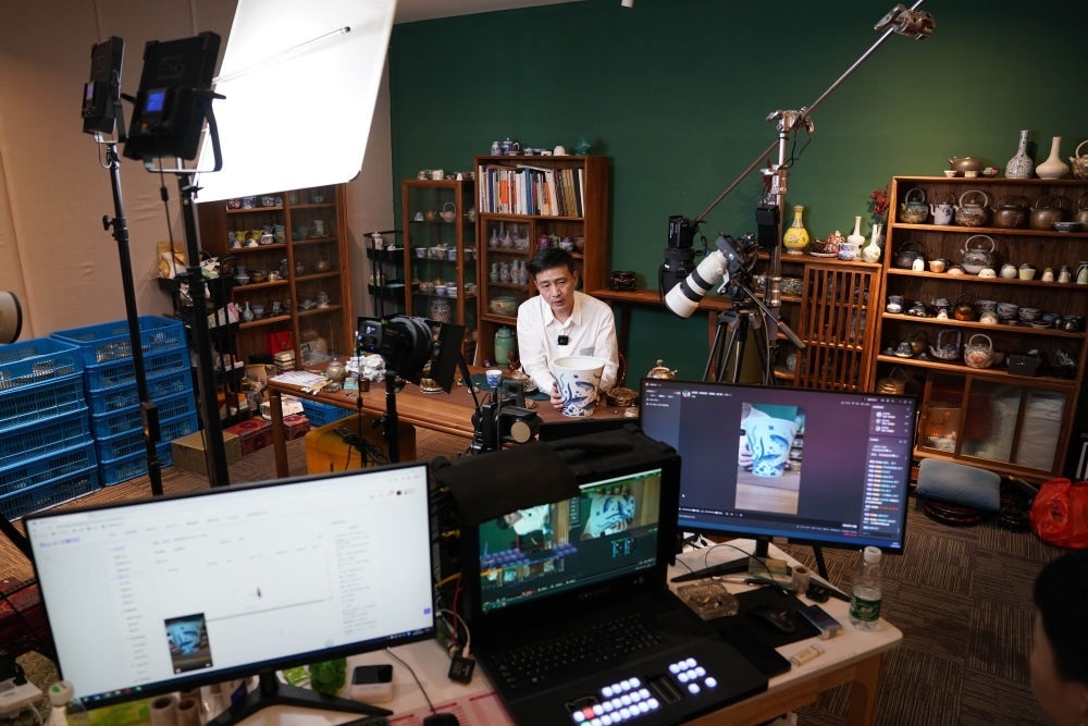 ↑在景德鎮(zhèn)，工作人員通過(guò)網(wǎng)絡(luò)直播推介陶瓷產(chǎn)品（2023年2月22日攝）。