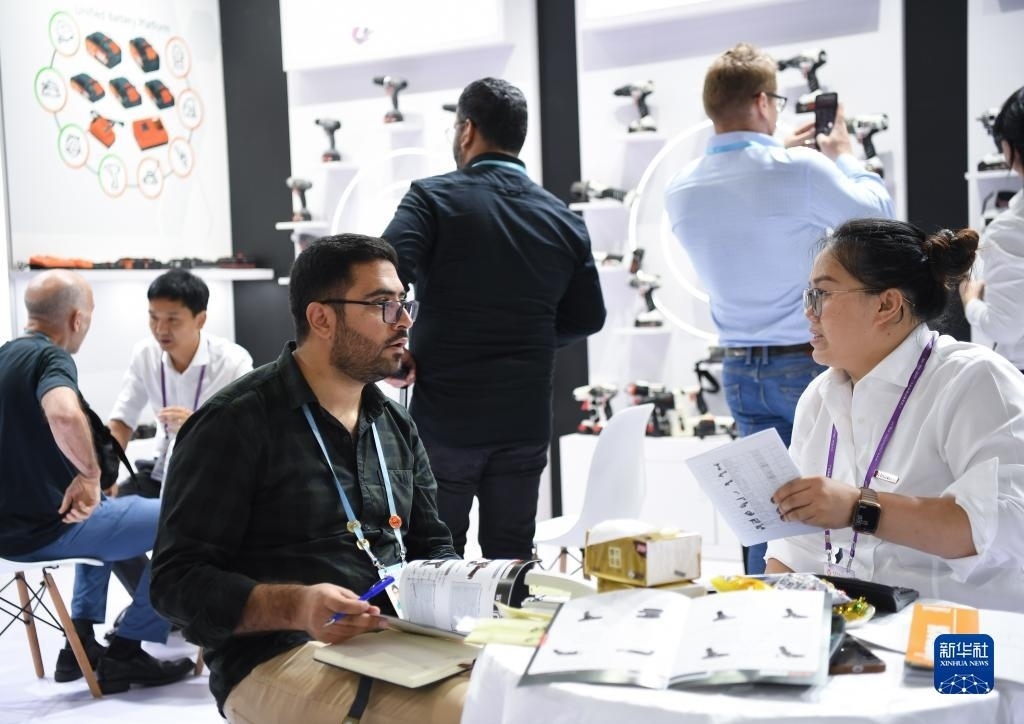 10月15日，在一家電動工具展臺，外國采購商在洽談業(yè)務(wù)。新華社記者 鄧華 攝