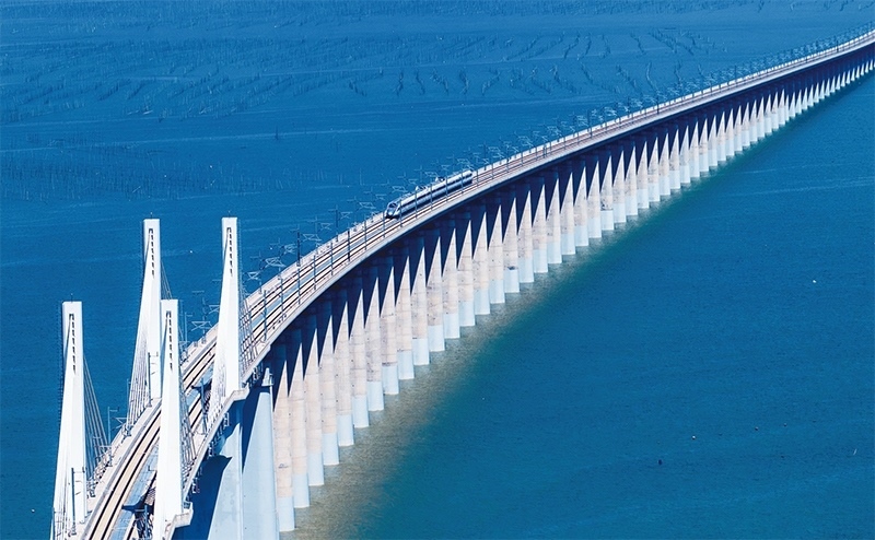 2023年9月28日，中國首條時速350公里跨海高鐵——福廈高鐵正式開通運(yùn)營。圖為一列運(yùn)行試驗(yàn)車組駛過福廈高鐵湄洲灣跨海大橋（9月19日攝，無人機(jī)照片）。 新華社記者 魏培全/攝
