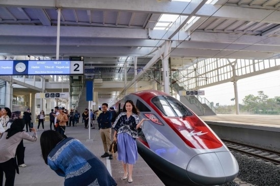  10月17日，在印度尼西亞萬隆德卡魯爾站，乘客在站臺上和雅萬高鐵高速動車組列車合影。新華社記者 徐欽 攝