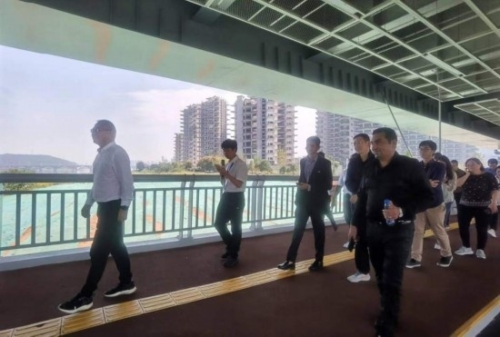 10月24日，2023“一帶一路”媒體合作論壇聯(lián)合采訪團(tuán)團(tuán)員走在清水塘大橋景觀通道上。本報(bào)記者 常雯宜攝