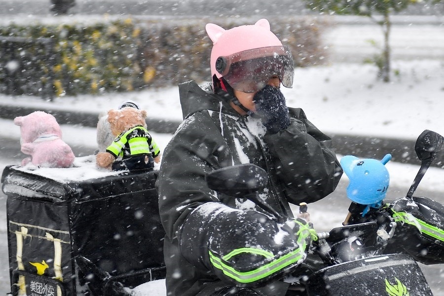 11月6日，在長(zhǎng)春市街頭，一名外賣員在雪中騎行。新華社記者 許暢 攝