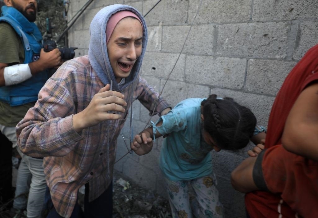 11月6日，人們從加沙地帶中部地區(qū)一處被炸難民營逃離。新華社發(fā)（亞西爾·庫迪攝）