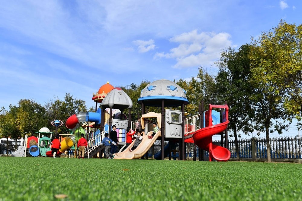 在山東省東營市墾利區(qū)楊廟社區(qū)幼兒園，孩子們在老師的帶領下進行戶外活動（2021年10月19日攝）。新華社記者 郭緒雷 攝