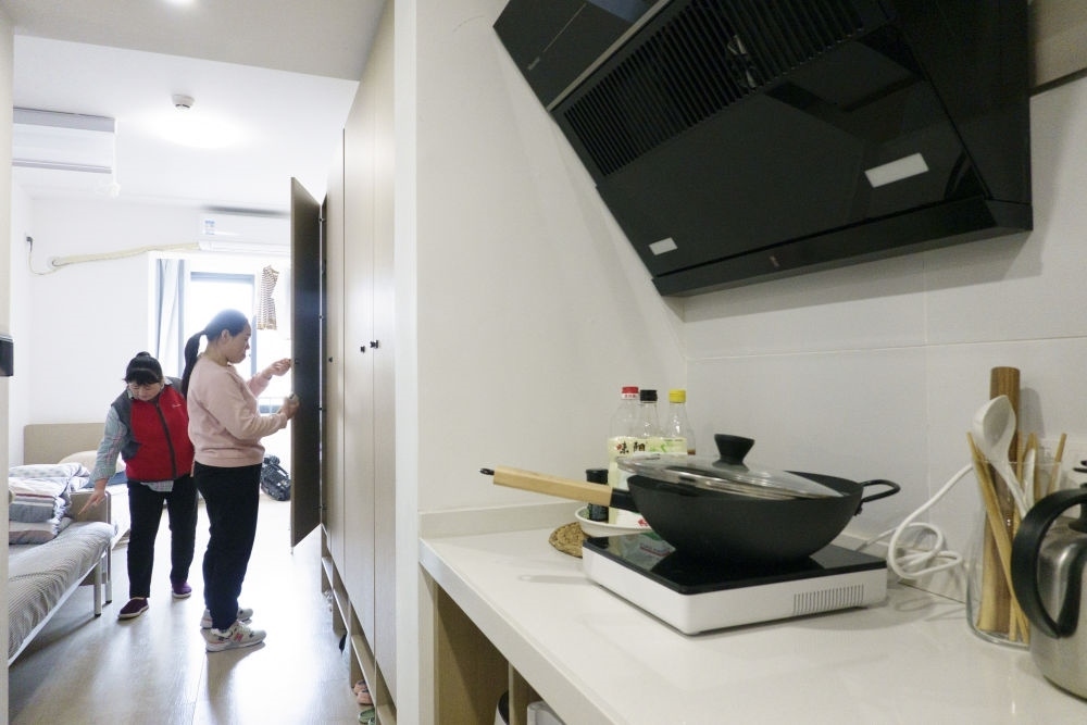 住戶在閔行區(qū)新時代城市建設者管理者之家收拾房間。