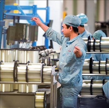 在位于武漢的長飛光纖光纜股份有限公司光纖生產(chǎn)車間內(nèi)，工作人員對光纖進(jìn)行檢測（資料圖片）。肖藝九攝/本刊