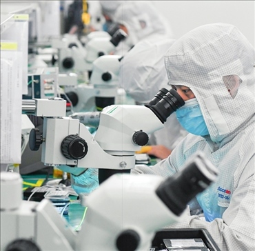 在位于武漢中國光谷的光電器件研發(fā)制造商——武漢光迅科技股份有限公司生產(chǎn)車間內(nèi)，技術(shù)人員在光模塊生產(chǎn)線作業(yè)（2023年4月11日攝）。程敏攝/本刊