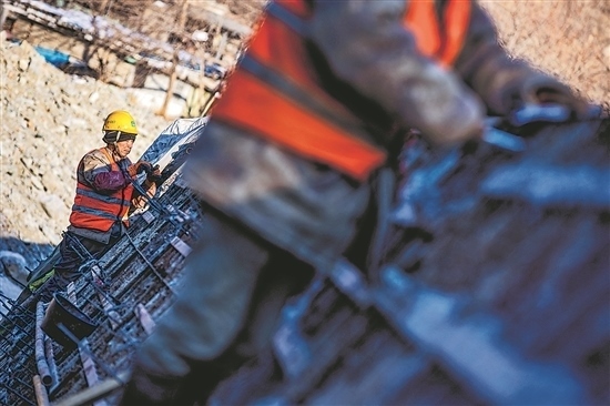 1月3日，房山區(qū)，工人正在雙泉河修筑堤壩。