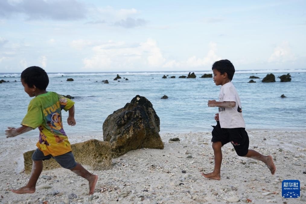 1月20日，兒童在瑙魯海邊嬉戲。新華社記者 王申 攝