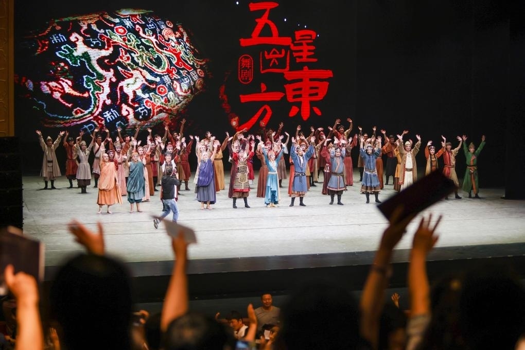 2023年7月31日，新疆和田地區(qū)新玉歌舞團在烏魯木齊京劇院演出舞劇《五星出東方》后和觀眾互相揮手致意。這場演出是第六屆中國新疆國際民族舞蹈節(jié)的參演劇目之一，曾榮獲國家“文華獎”等。新華社記者 郝昭 攝