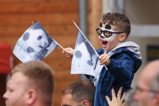  2023年7月26日，在法國(guó)圣艾尼昂市博瓦勒野生動(dòng)物園外，一名兒童等待送別熊貓“圓夢(mèng)”。新華社記者 高靜 攝
