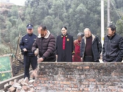  圖③：庭審結(jié)束后，在法官的見(jiàn)證下，陳某在院壩邊重新開(kāi)鑿一條通道。