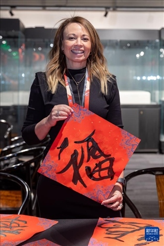 1月28日，在上海豫園舉行的民俗活動上，美國馬斯卡廷初中校長珍妮弗·李·弗里德利展示自己寫下的“?！弊?。 新華社記者 王翔 攝