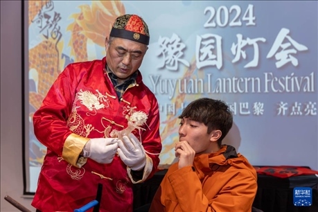 1月28日，在上海豫園舉行的民俗活動上，美國馬斯卡廷中學學生在非遺傳承人的指導下吹糖偶。 新華社記者 王翔 攝