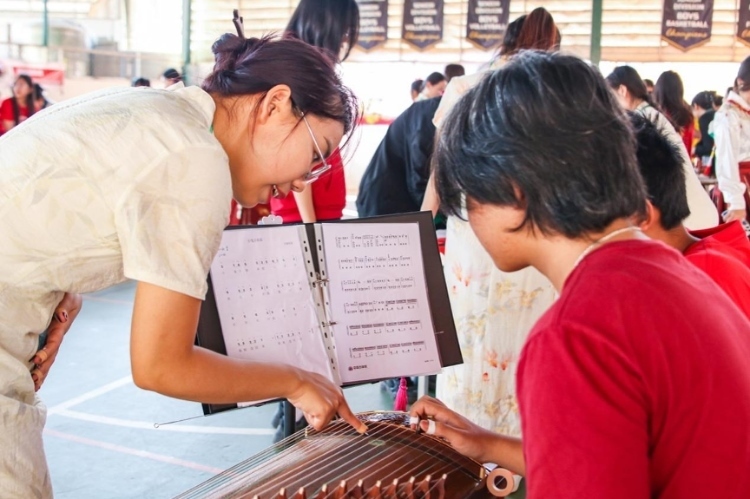 志愿者教師指導(dǎo)學(xué)生彈奏古箏?；顒?dòng)主辦方供圖