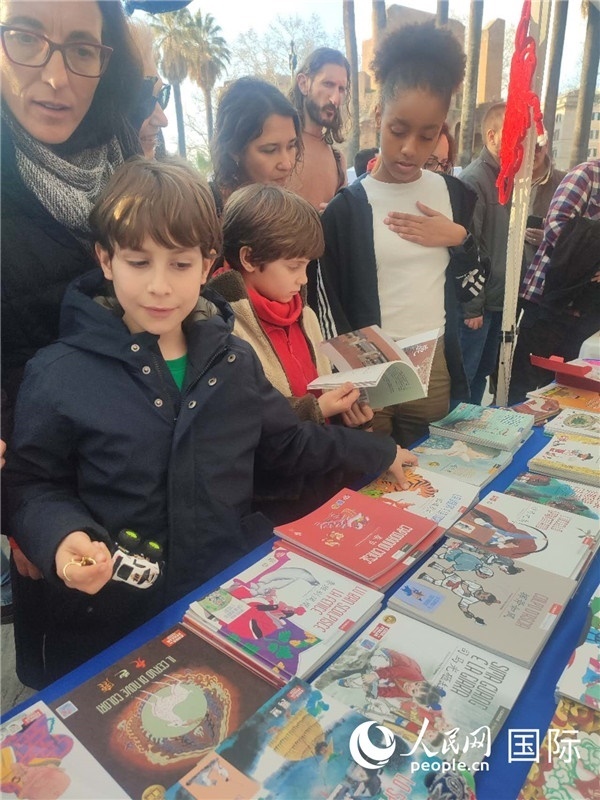 印刷精美的中國傳統(tǒng)文化叢書吸引了小游客的注意。人民網(wǎng)記者鄭彬攝