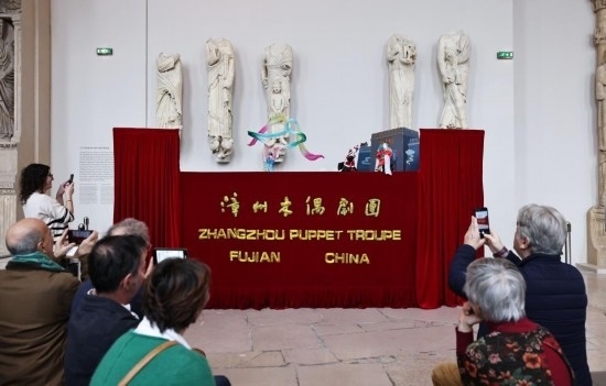 2月10日，在位于法國巴黎埃菲爾鐵塔附近的“建筑與遺產之城”博物館，觀眾欣賞漳州布袋木偶戲。新華社記者高靜攝
