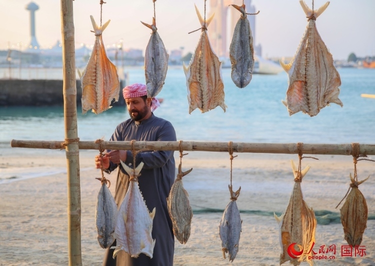  手工藝者展示如何晾曬魚干。人民網(wǎng) 塔里克·易卜拉欣攝