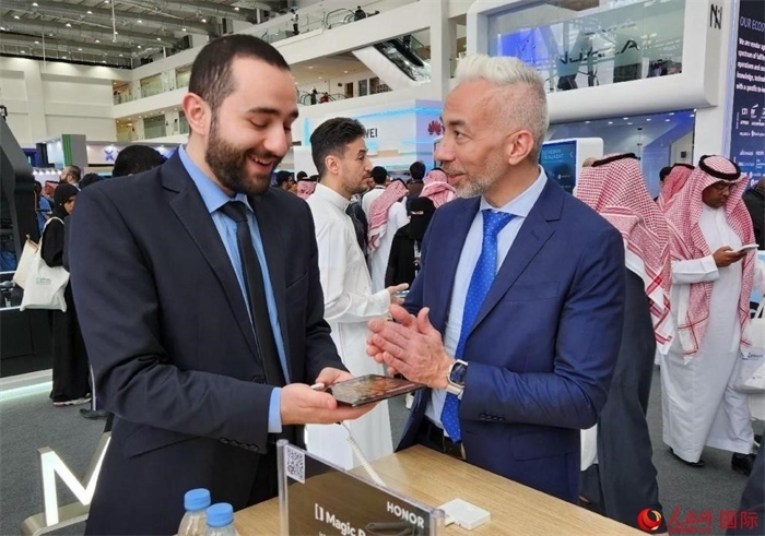 兩名觀眾在榮耀手機(jī)展臺(tái)前交流。人民網(wǎng)記者 管克江攝