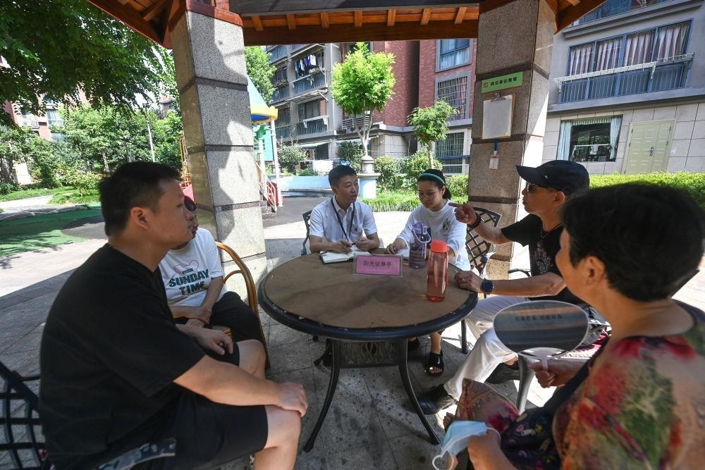 △2023年7月21日，在位于浙江杭州臨安區(qū)錦南街道水岸陽光小區(qū)的陽光議事廳，街道干部在聽取居民們反映的問題及意見。