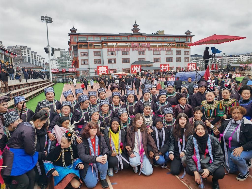 法國(guó)青年在“村超”賽場(chǎng)邊與參加表演的村民合影。新華社記者 羅羽 攝