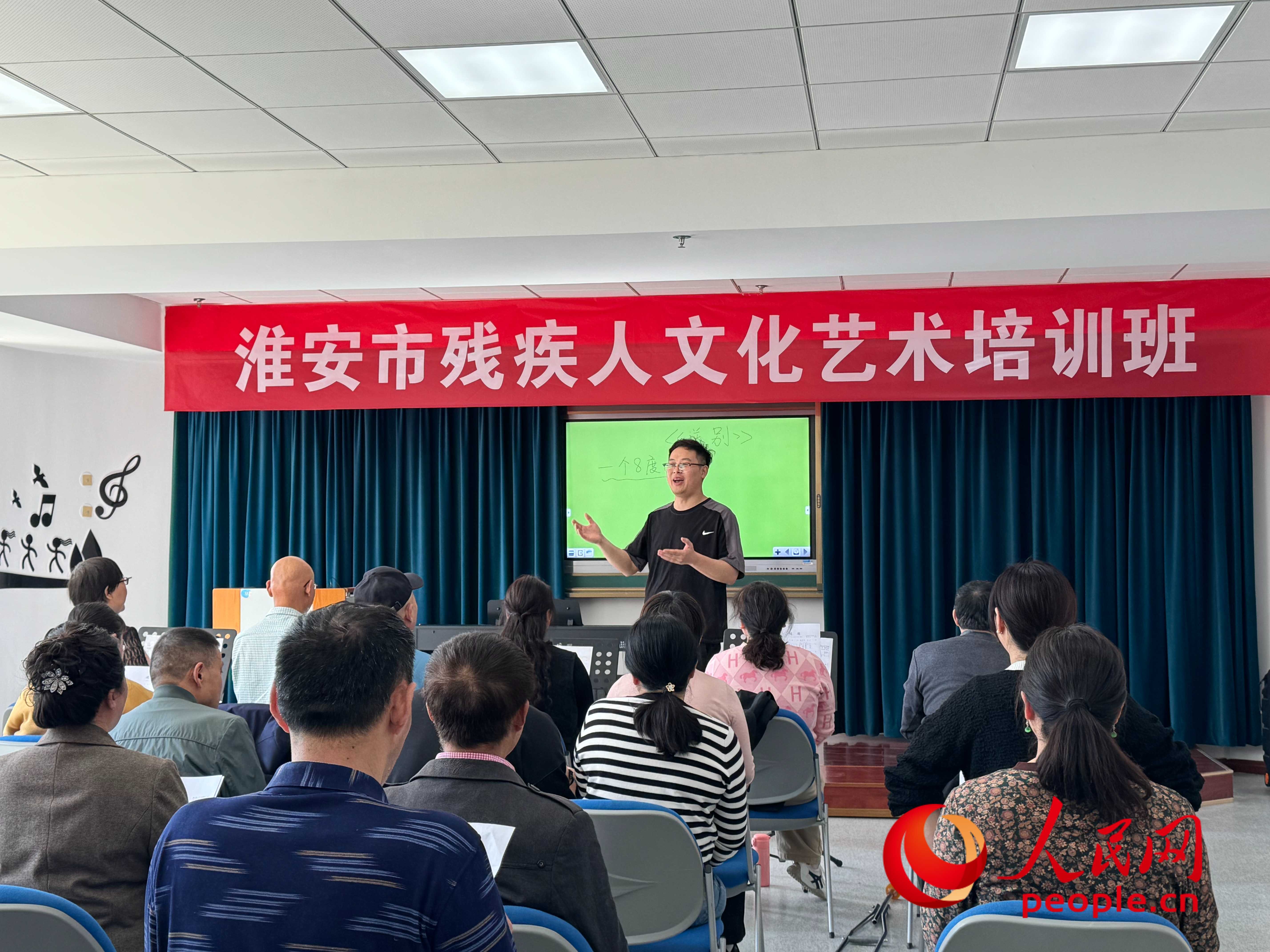 在淮安市殘疾人文化藝術(shù)培訓(xùn)班上，聲樂老師在教殘疾人唱《送別》這首歌曲。人民網(wǎng) 周靜圓攝
