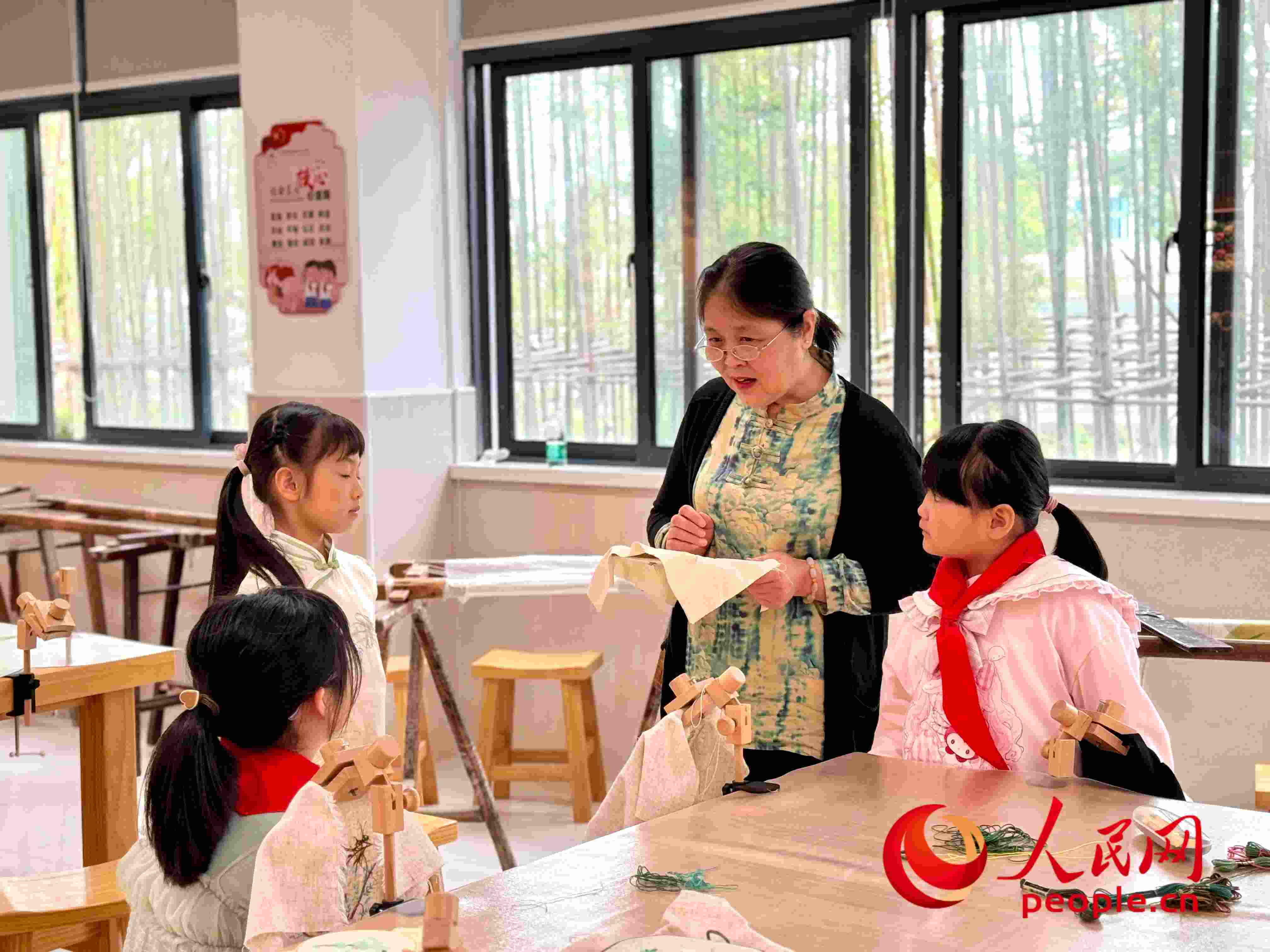 顧建珍（左三）在教孩子們刺繡知識(shí)。人民網(wǎng) 周靜圓攝