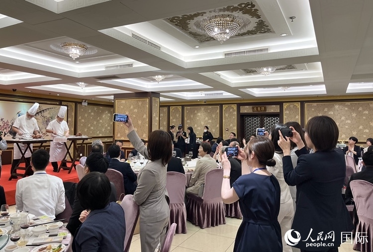 國家級非物質(zhì)文化遺產(chǎn)、全聚德片鴨工藝吸引代表團成員拍照留念。