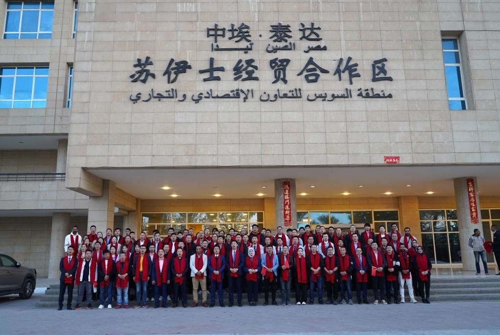 2024年2月11日，在位于埃及蘇伊士省的中?！ぬ┻_蘇伊士經(jīng)貿(mào)合作區(qū)，中埃員工在合作區(qū)辦公大樓前合影拜年。新華社發(fā)（泰達合作區(qū)供圖）